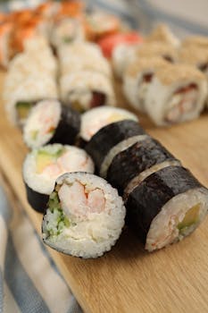 Close-up of mouth-watering sushi rolls on a wooden platter showcasing a variety of flavors and textures.