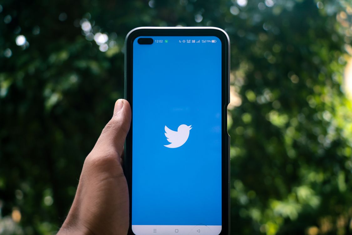 hand holding smartphone Twitter app