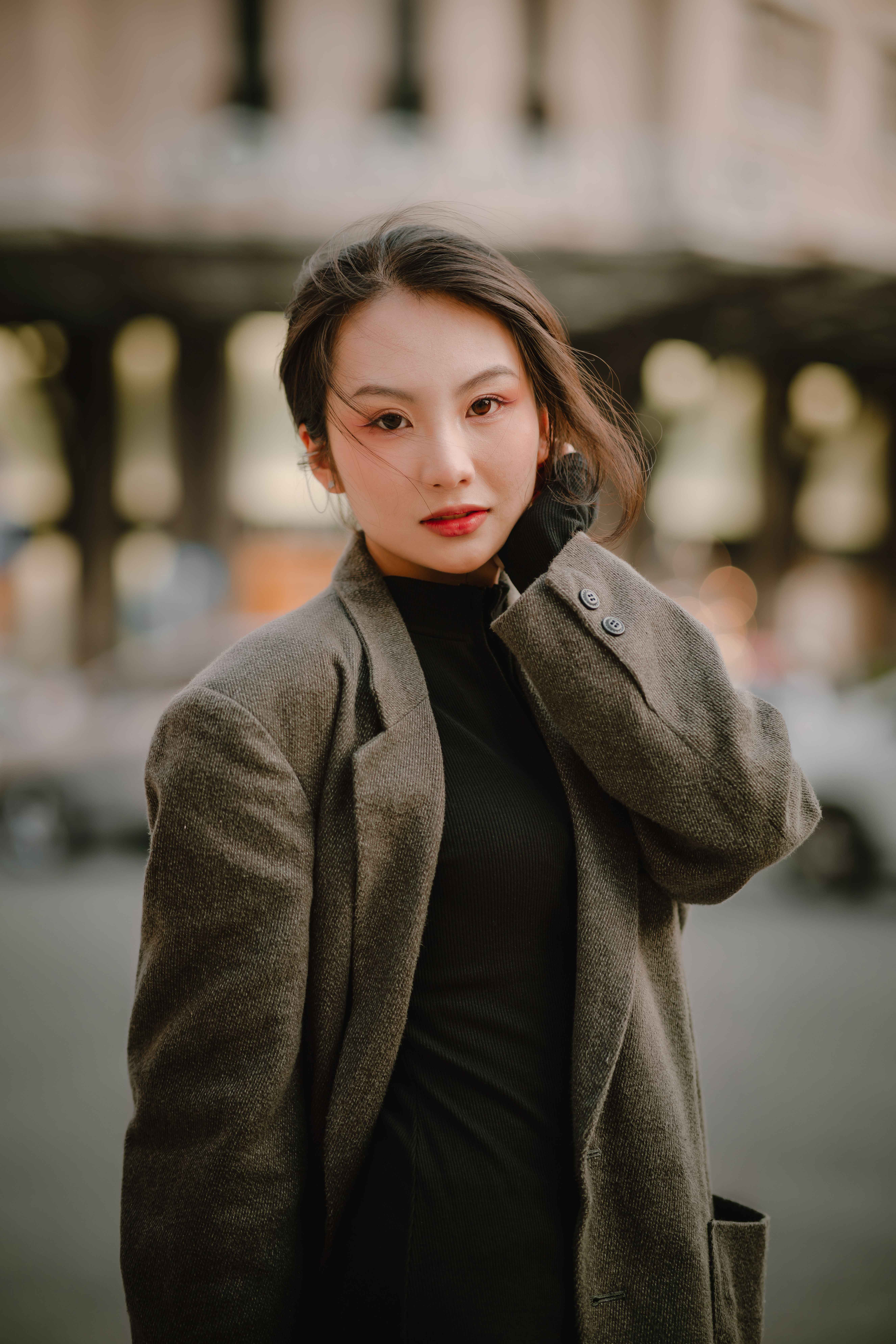 Elegant woman in a city street wearing a stylish coat, showcasing urban fashion.