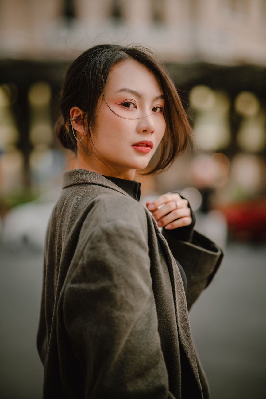 Urban portrait of a woman in a coat with soft natural lighting. Perfect for fashion and lifestyle themes.