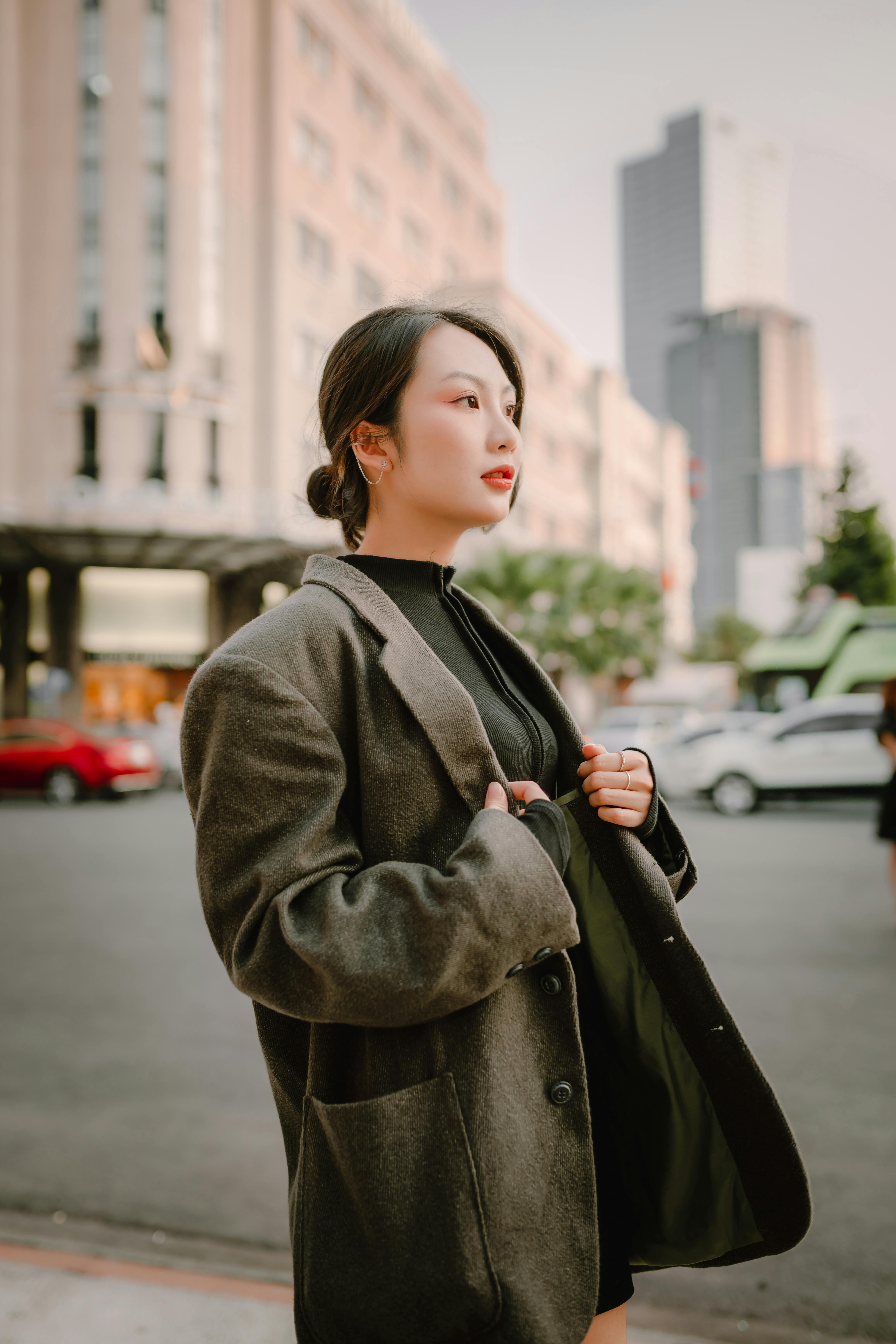 Portrait of a stylish Asian woman in city street, showcasing fashion and elegance.
