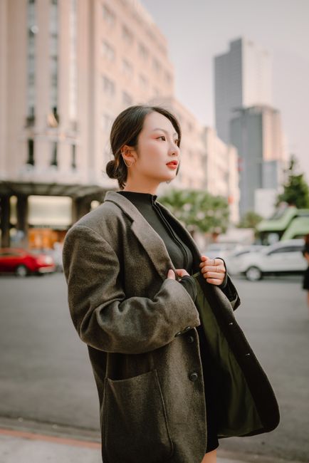 Portrait of a stylish Asian woman in city street, showcasing fashion and elegance.