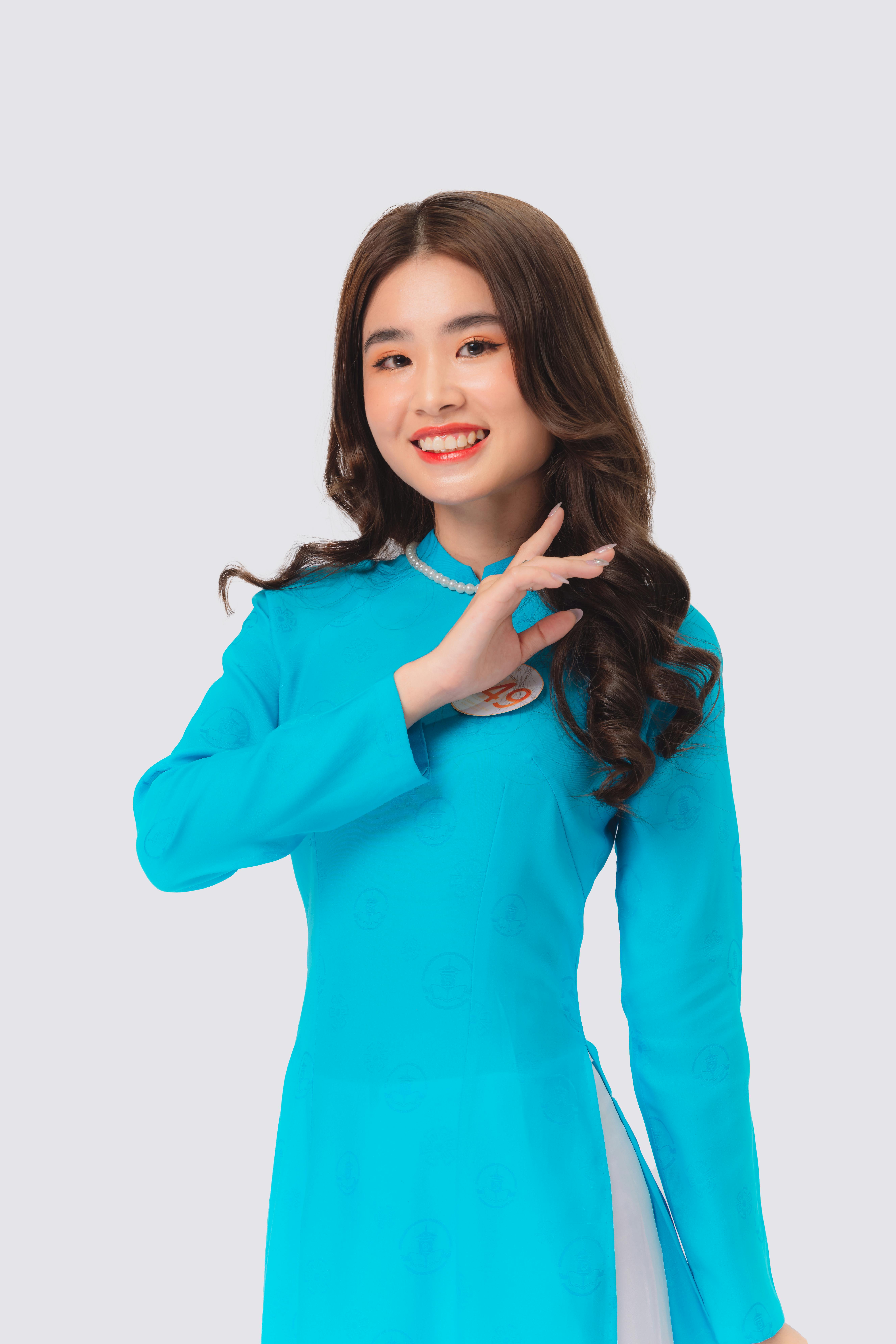Charming woman in a vibrant traditional dress smiling against a white background.