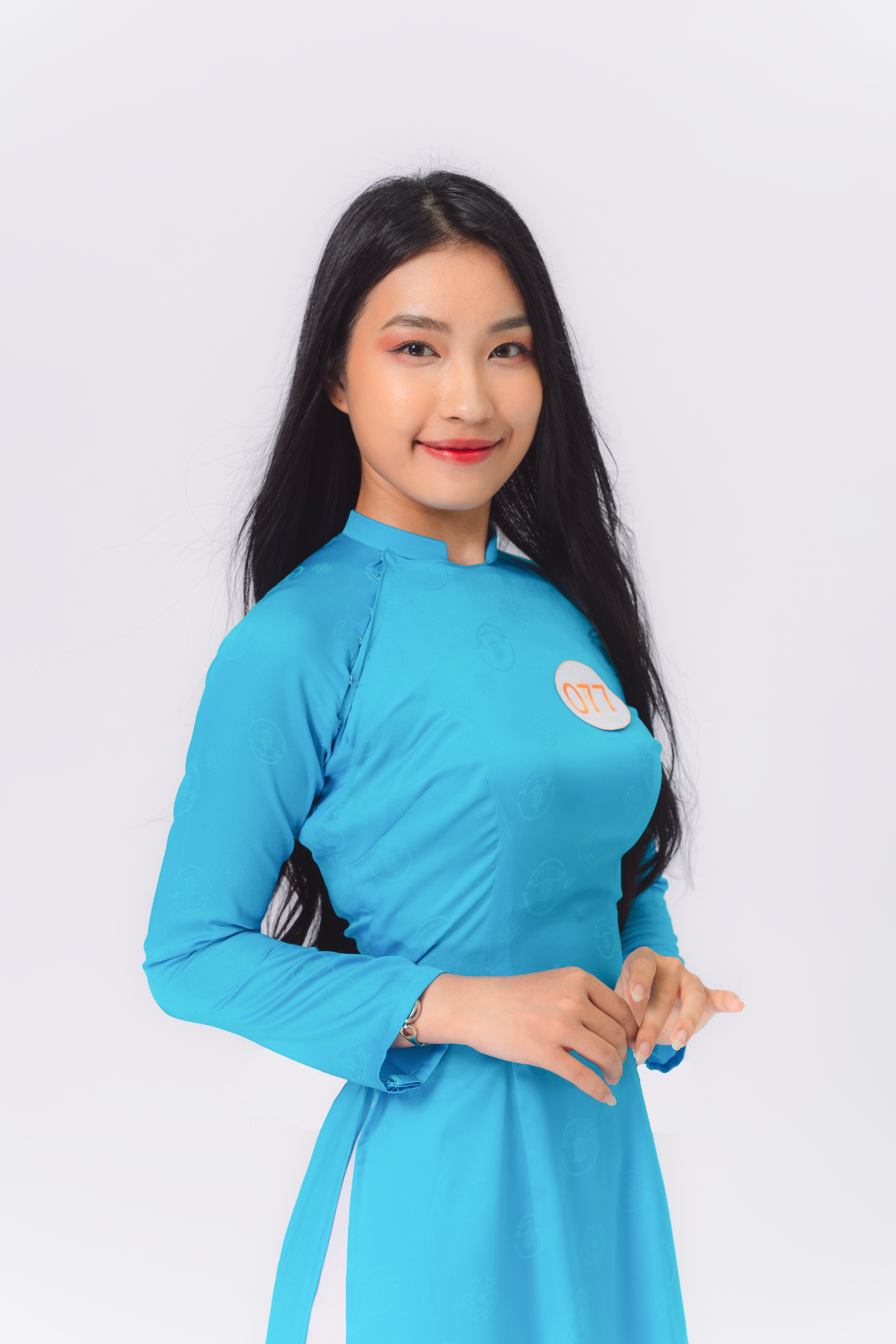 Discover elegance in this portrait of a smiling woman in a blue traditional dress, exuding grace.