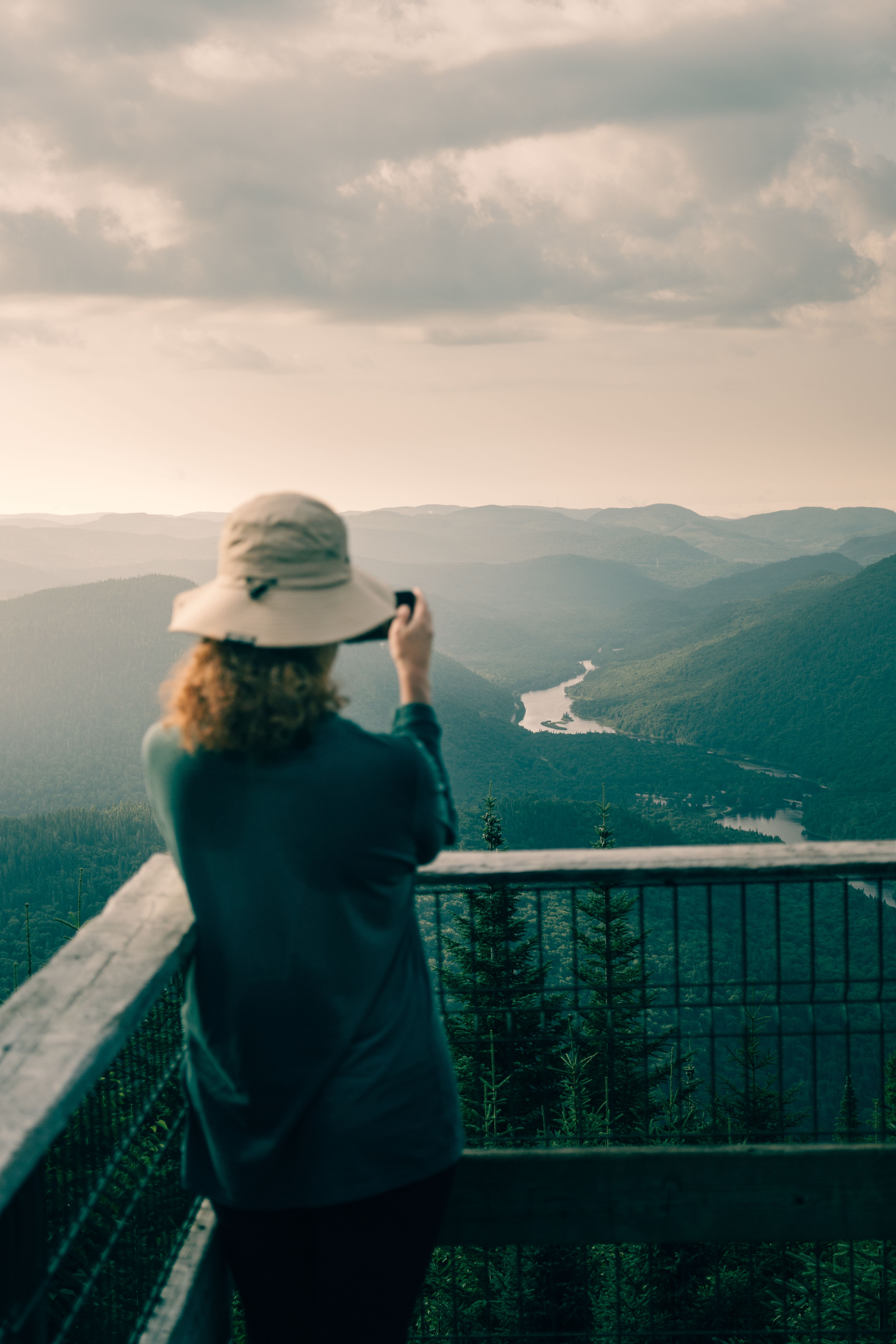 Woman capturing the misty landscape of Jacques-Cartier National Park at dawn, Quebec, Canada.