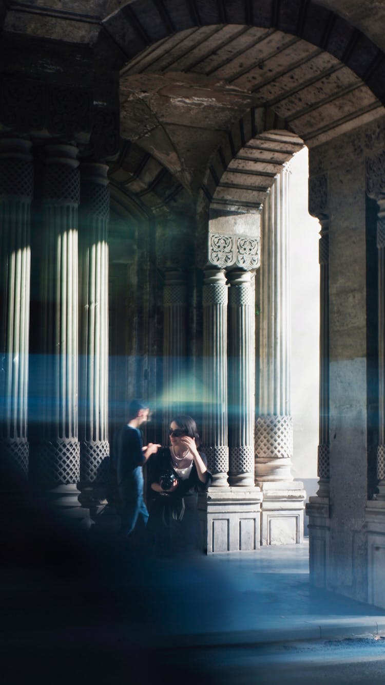 Man And Woman Walking Under Arched Street