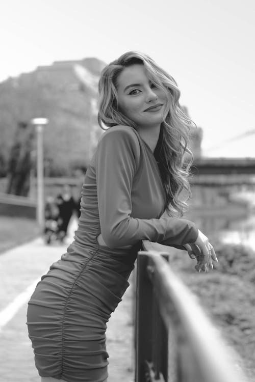 Black and White Shot of a Beautiful Woman Standing on the Bridge 