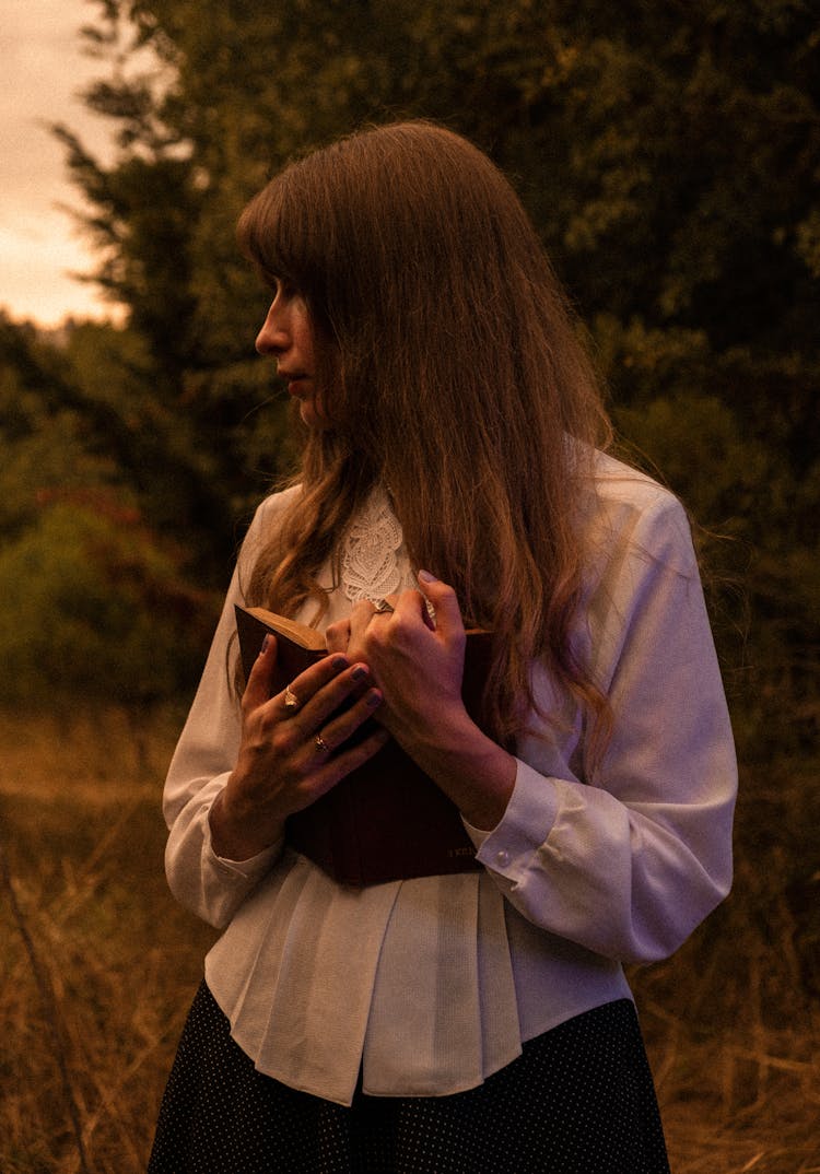 Woman In White Shirt Standing With Book