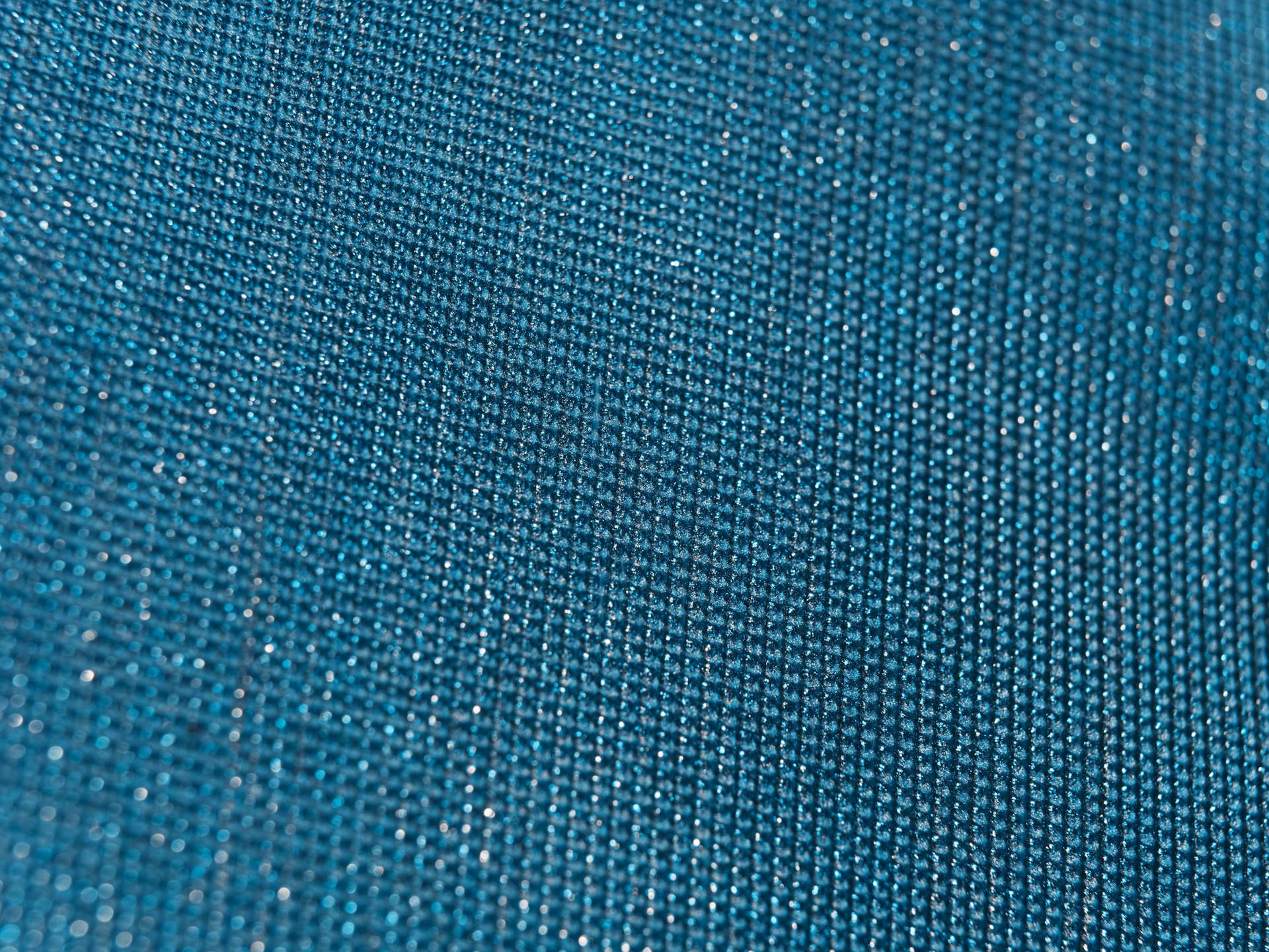 Close-up view of sparkling blue textured fabric with shimmering quality.