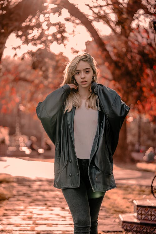 Blonde Woman in Jacket in Park in Autumn