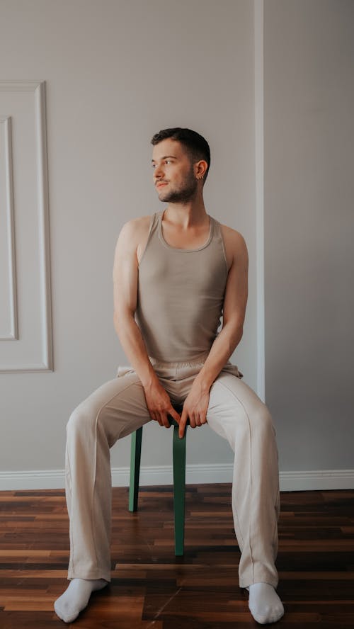 Young Man in a Casual Outfit Sitting on a Chair 
