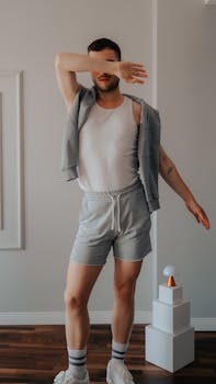 Man in casual sportswear posing stylishly in a modern indoor studio.