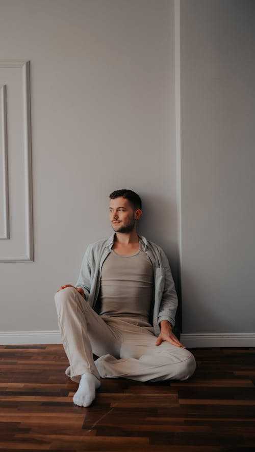 Young Man in a Casual Outfit Sitting on the Floor