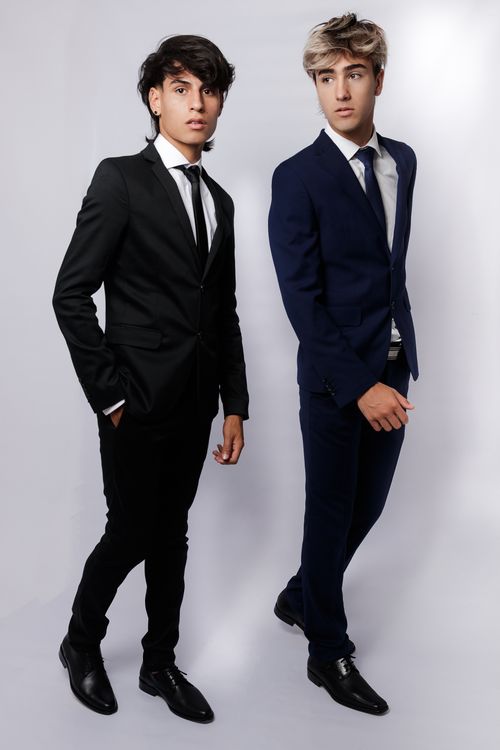Free Elegant fashion portrait of two young men in stylish suits against a white backdrop, exuding modern elegance. Stock Photo