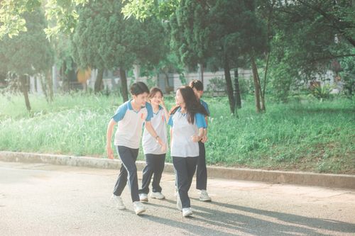 Free Group of teenagers in matching uniforms walking and having fun in a park setting. Stock Photo