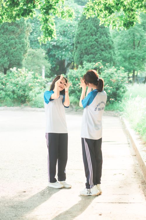 Free Two teenage girls enjoy a playful moment outdoors, dressed in sportswear on a sunny day. Stock Photo