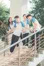 Group of School Students in Uniform T-Shirts Posing on Stairs