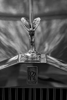 Dramatic black and white photo of the Rolls-Royce hood ornament showcasing luxury and elegance.