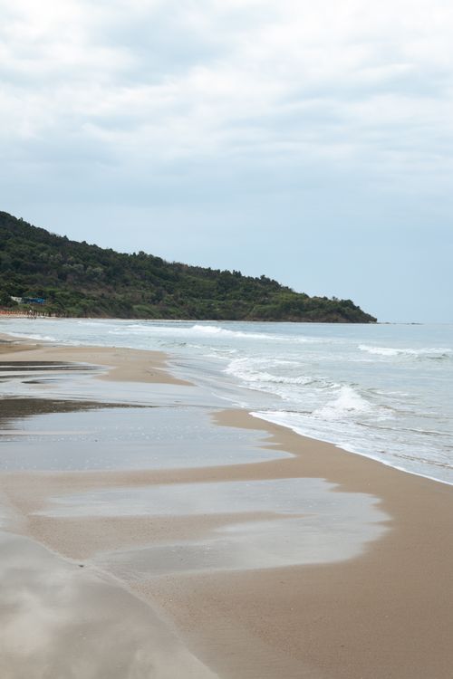Free Serene beach scene in Durrës, Albania featuring gentle waves and sandy shores under a cloudy sky. Stock Photo