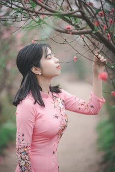 一位身穿粉色澳黛的妇女在宁静的公园里赏花