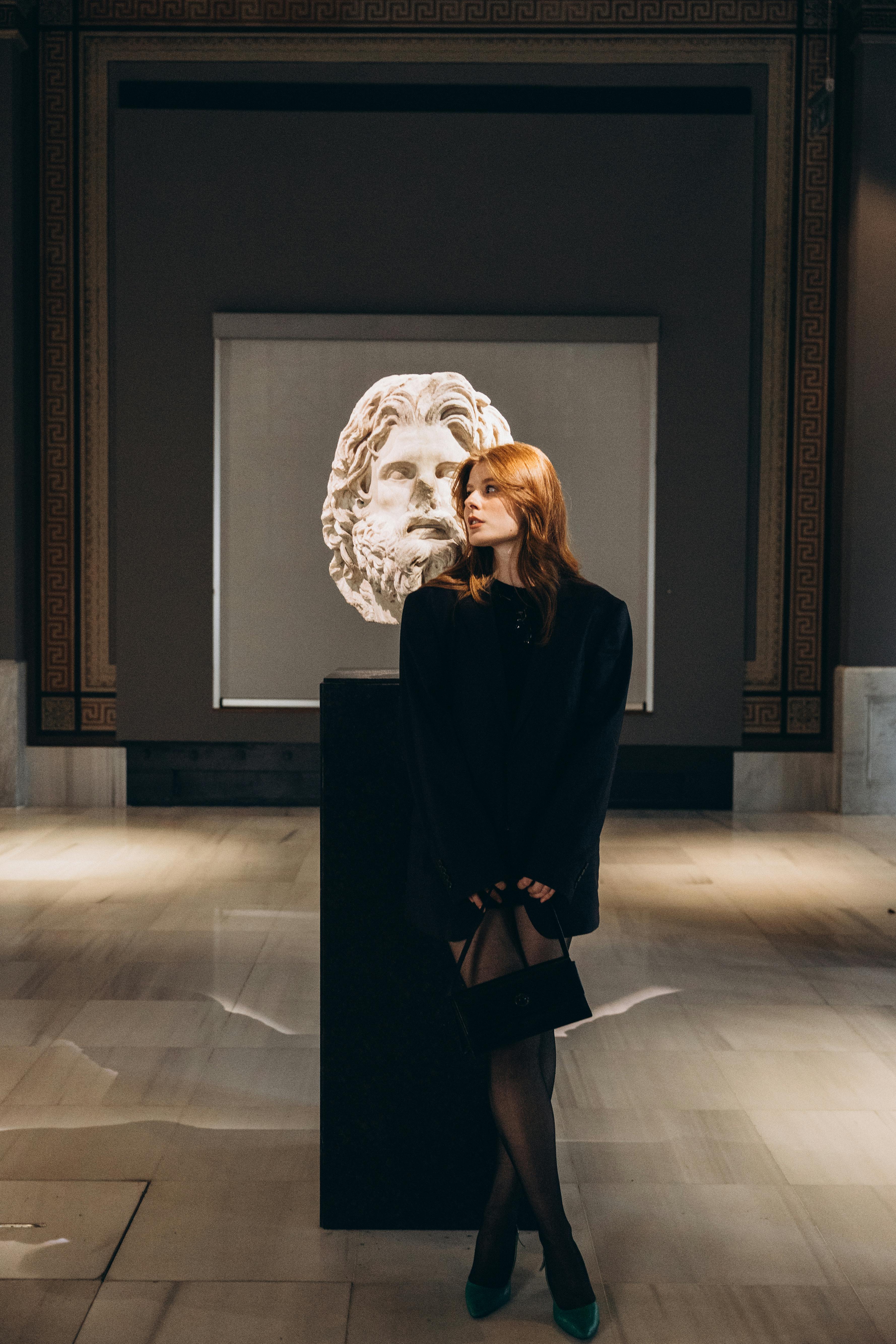 a woman standing in front of a statue