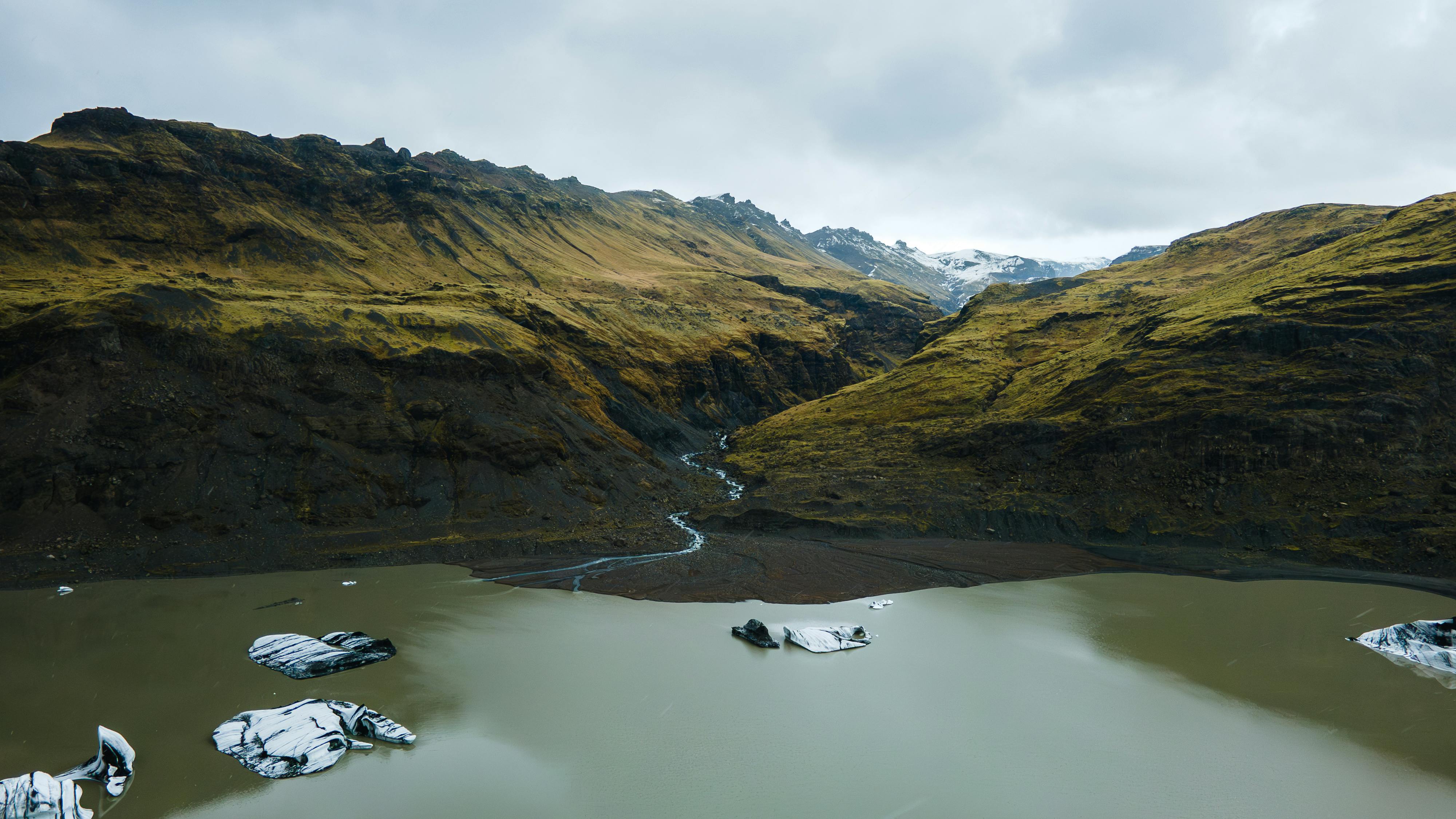 Stunning aerial view of a glacial lake in Iceland surrounded by rugged mountains.