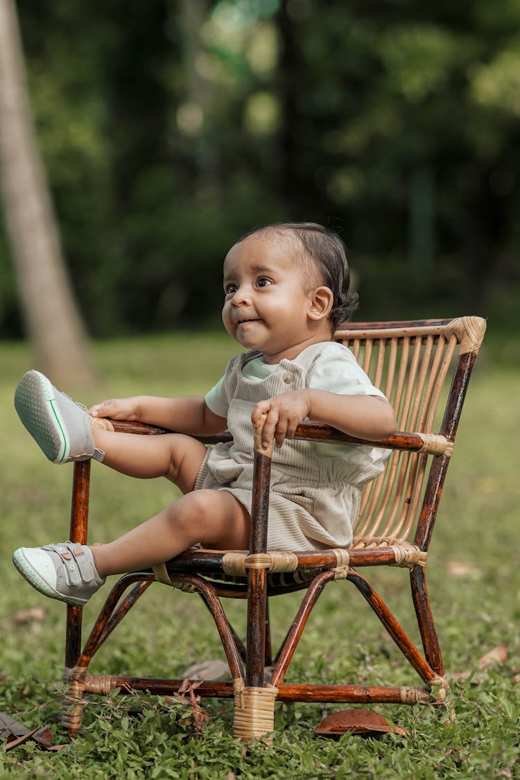 Toddler Sitting On A Wooden Chair