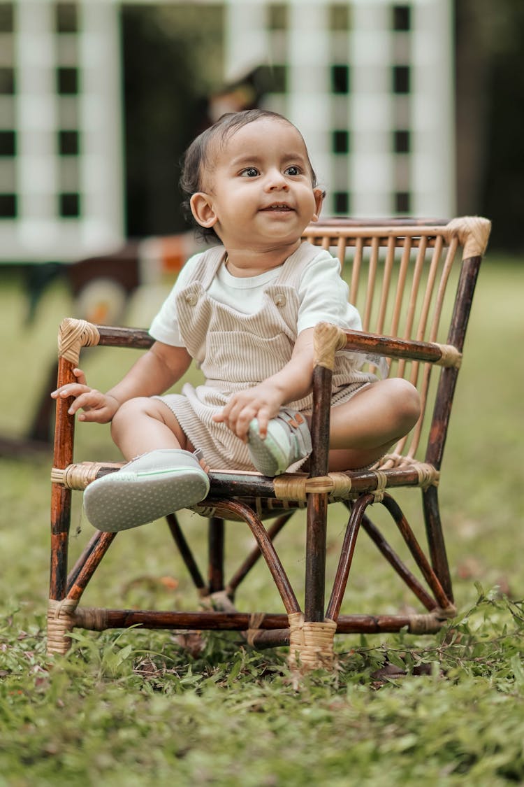 Toddler Sitting On An Outdoor Chair