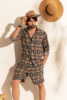Portrait of a stylish man in a patterned outfit and hat, Dhaka.