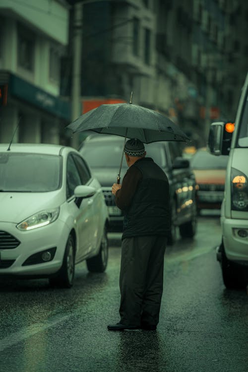 Elderly Man Standing on the Street in the Rain