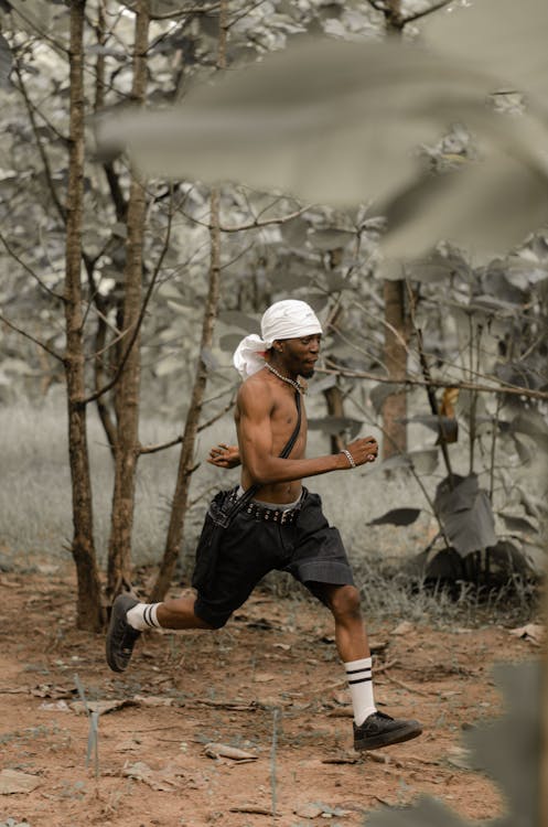 Shirtless Man Runs in Forest