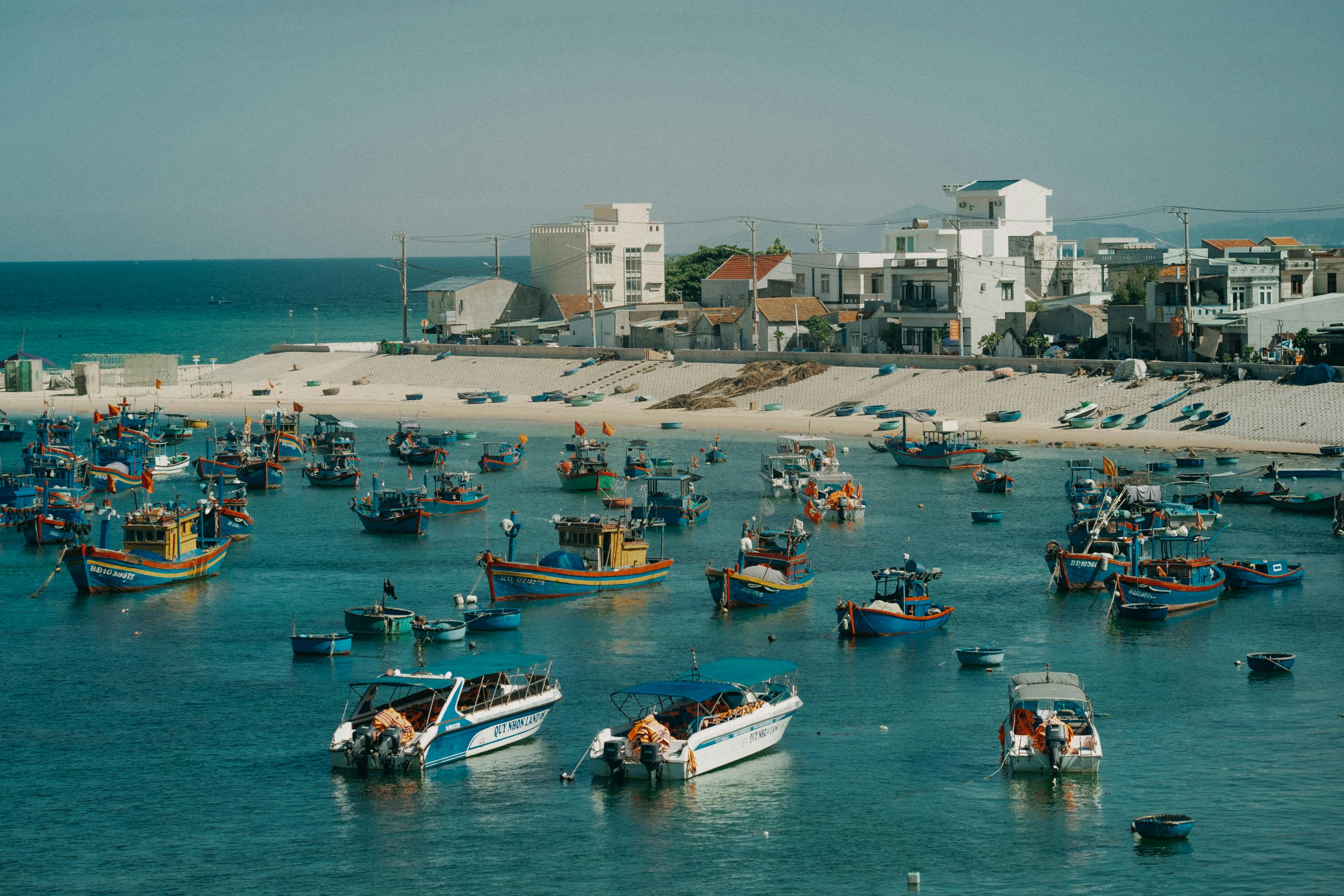 A bustling harbor filled with colorful fishing boats under a clear blue sky.