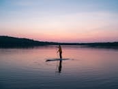 日落时分，金色的色调映照在湖面上，一个人安静地划着桨