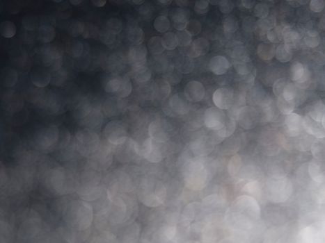Blurred bokeh lights creating a soft gray abstract background.