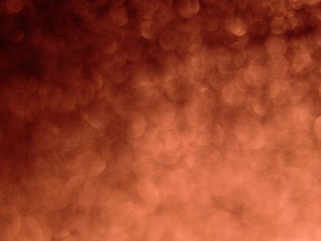 A blurred abstract orange bokeh pattern ideal for creative design uses.