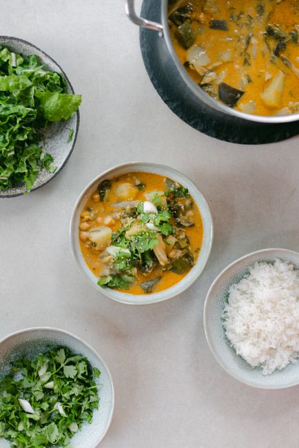 Top view of a delicious healthy vegetable soup with fresh greens and rice, ideal for food photography.