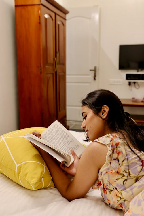 Brunette Woman Reading Book in Bed