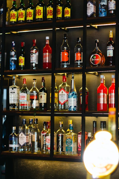 Bottles with Alcohol on Shelves in Bar