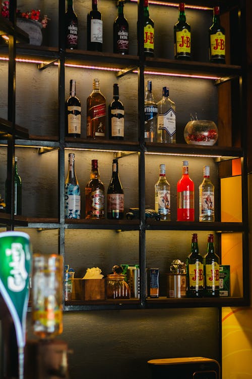 Bottles with Alcohol on Shelves in Bar