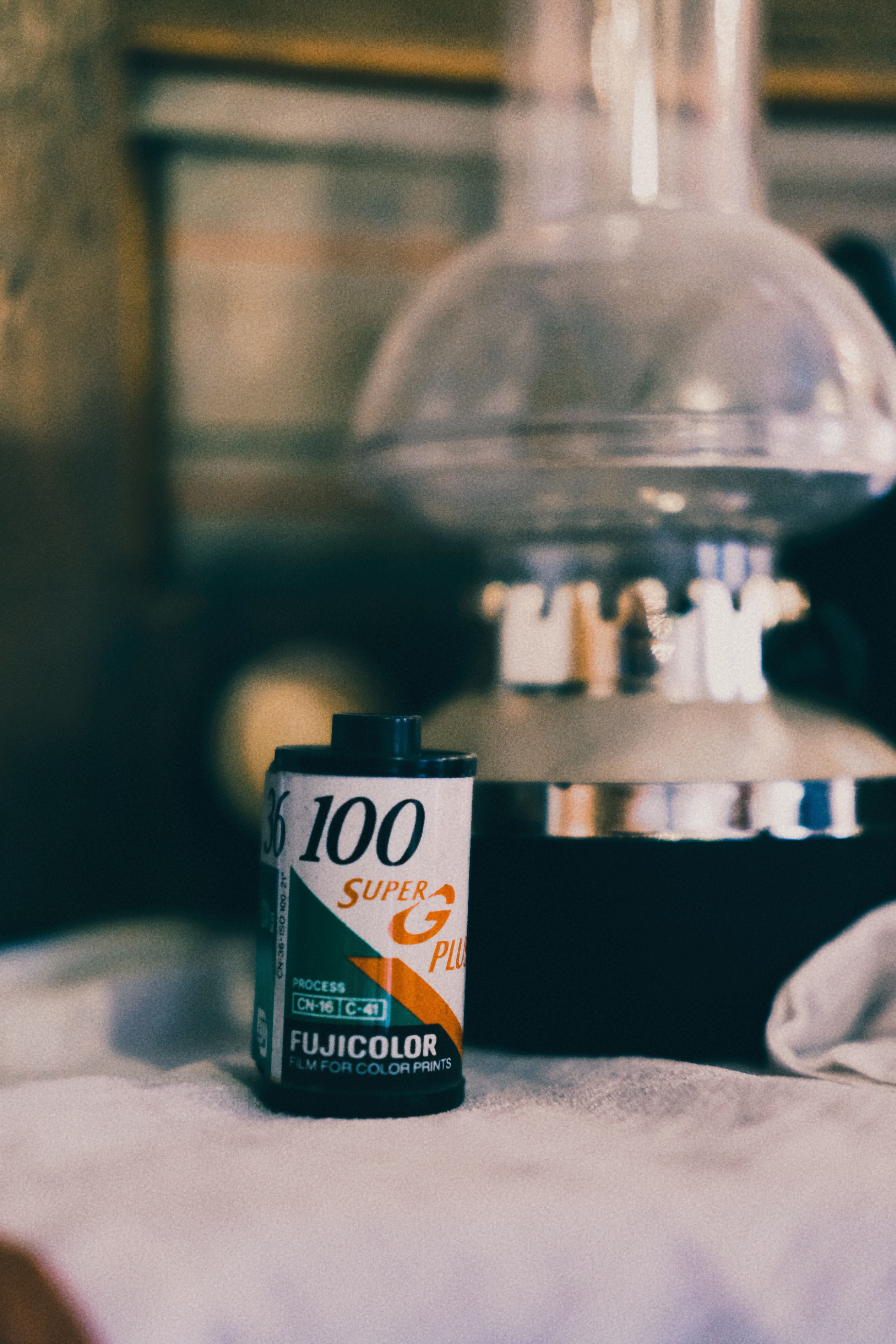 Close-up of a vintage film roll with a retro lamp in soft focus, evoking nostalgia.