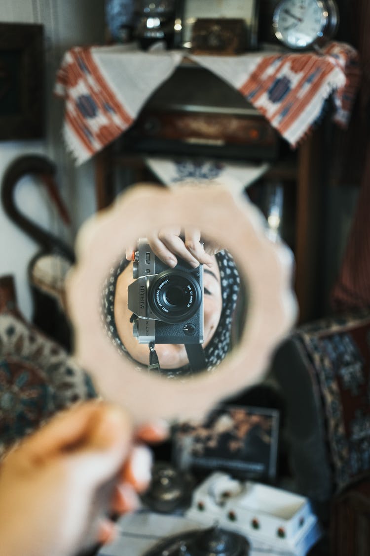 Woman With Camera Reflecting In Mirror