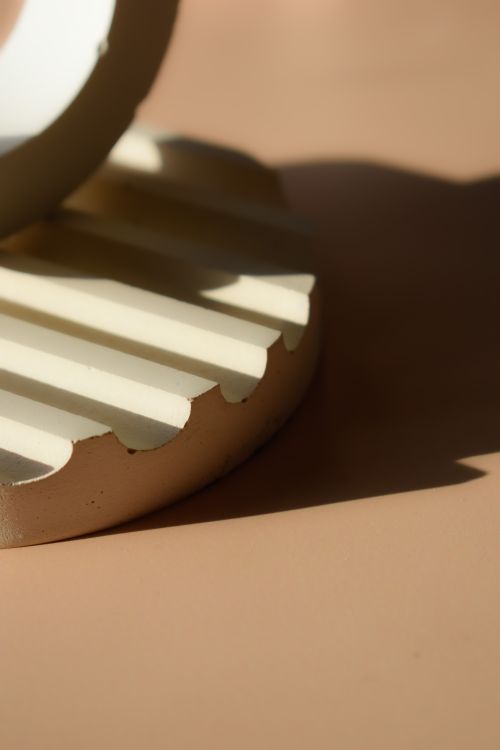 Free Close-up of a minimalist sculpture on a sunlit surface casting dramatic shadows. Stock Photo