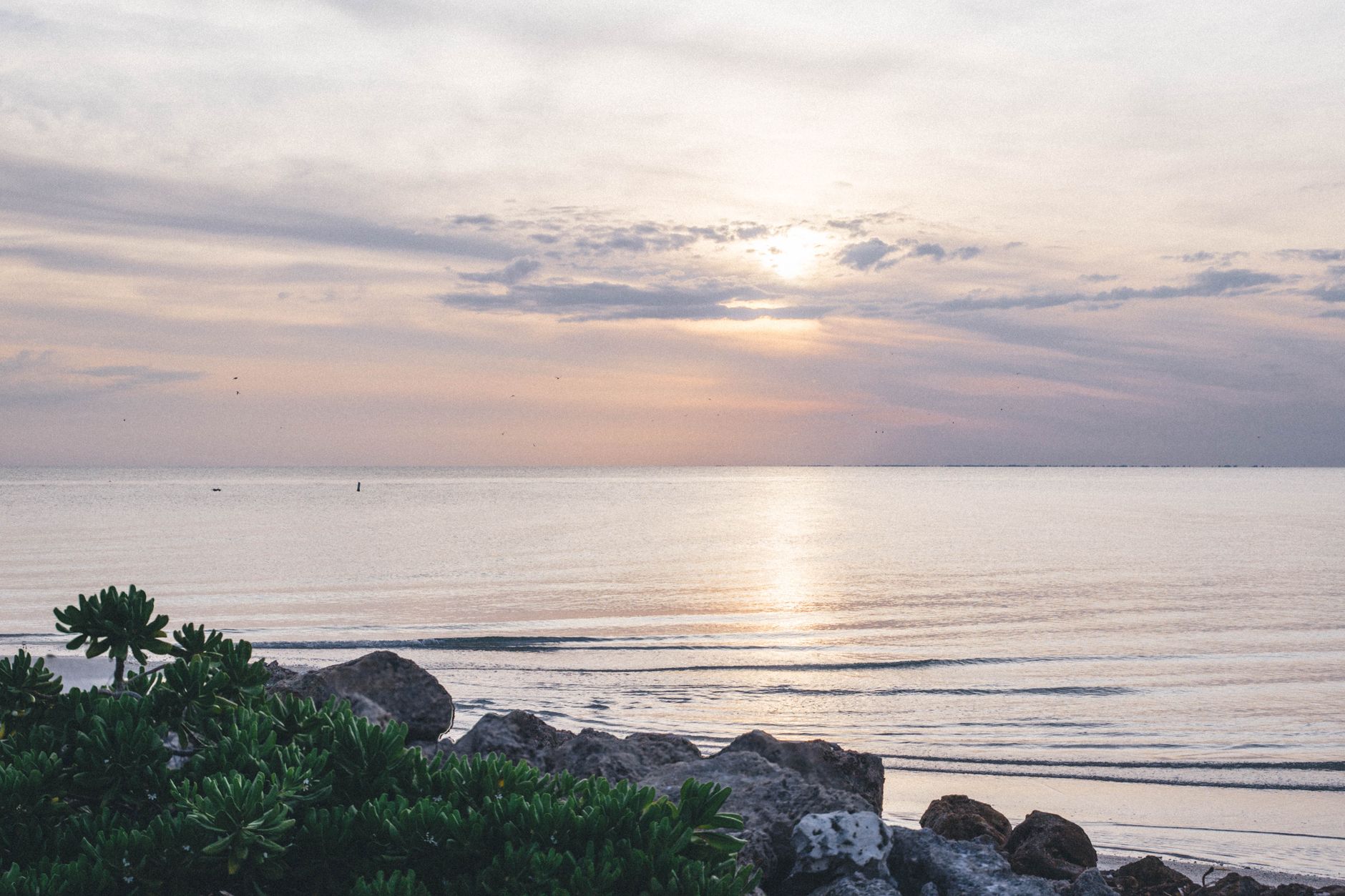 Peaceful sunset view over the ocean at Bonita Springs, capturing serene waves and a vibrant sky.