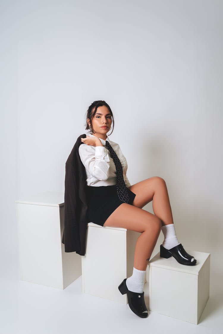 Brunette Woman Posing In Black Blazer, Mini Skirt And Tie