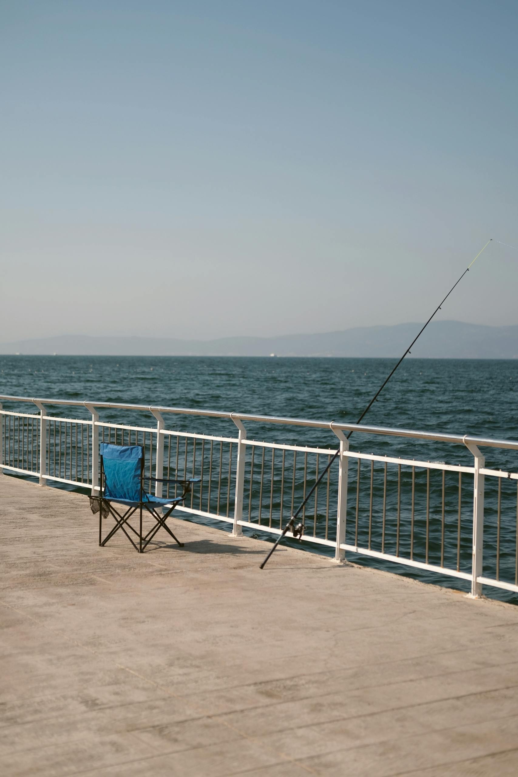 Empty fishing chair by the sea on a clear day, perfect for a peaceful escape.