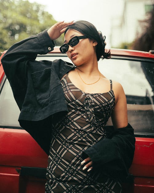 Young Woman Posing in Black Jacket and Brown Plaid Dress