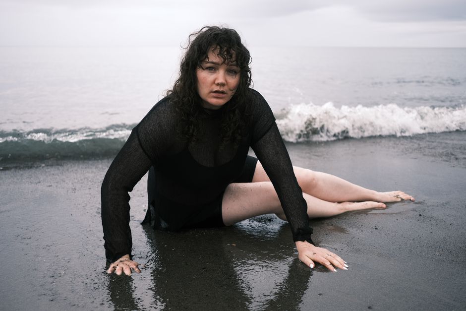 Woman in black outfit on Killiney Beach, Ireland, during a moody day.