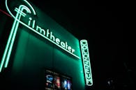 霓虹灯电影院标志在夜间闪闪发光，充满活力