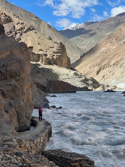 Free A picturesque mountain valley with a river flowing, showcasing rugged cliffs and natural beauty. Stock Photo