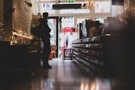 在阿姆斯特丹一家舒适的商店里，一名男子身着剪影，灯光柔和，气氛温馨地站着